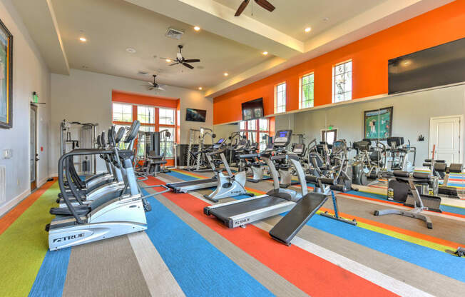 a gym with treadmills and other exercise equipment and windows at Hacienda Club, Jacksonville, Florida