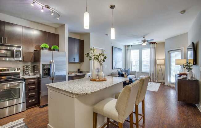 A modern kitchen with a center island and stainless steel appliances.