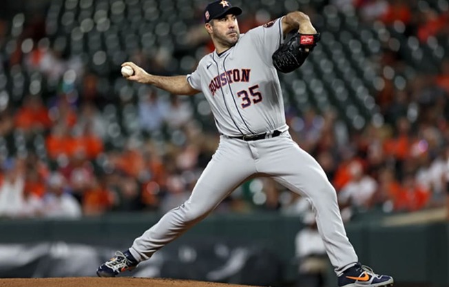 baseball player throws a pitch during a game