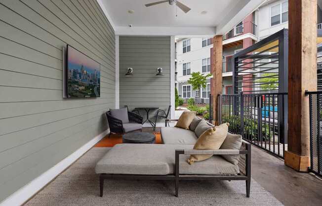 A balcony with a table and chairs and a painting on the wall.