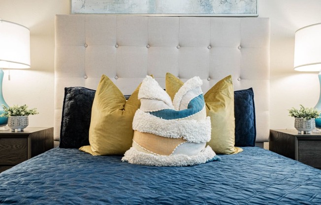 a bedroom with a bed with pillows and a blue blanket