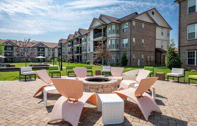 an outdoor lounge area with chairs and a fire pit at the enclave at woodbridge apartments in