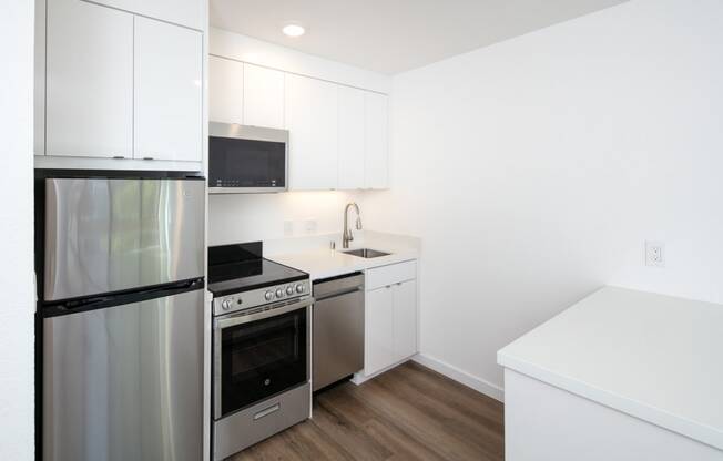 a kitchen with white cabinetry and stainless steel appliances