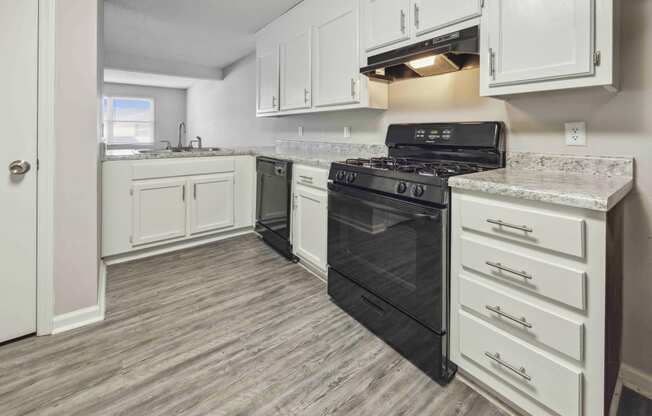 a kitchen with white cabinets and a black stove