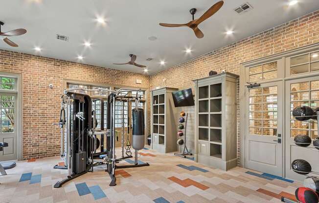 A gym with a brick wall and a variety of equipment.