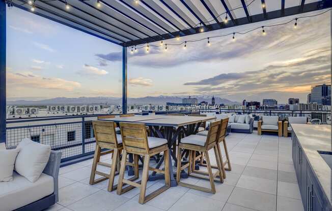 a terrace with a table and chairs and a view of the city