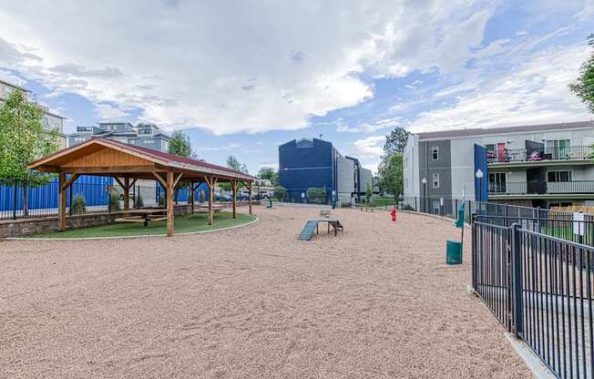 a playground with a pavilion and picnic table in a park