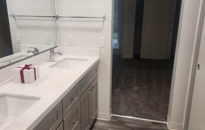 A bathroom with a white sink and a mirror.