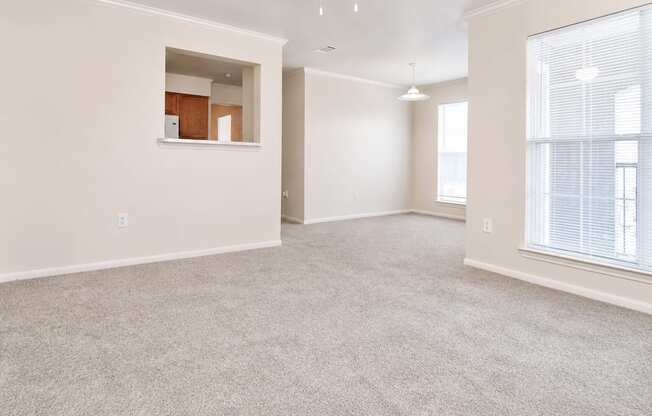 A spacious room with a window and a ceiling fan.