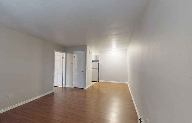 Inviting apartment showcasing sleek hardwood flooring, modern lighting, and a neutral palette perfect for personalization.