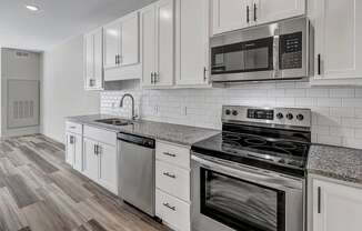 a kitchen with white cabinets and stainless steel appliances