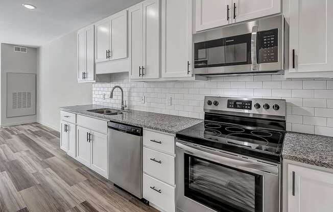 a kitchen with white cabinets and stainless steel appliances