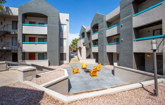 A modern courtyard with a concrete floor and yellow chairs.