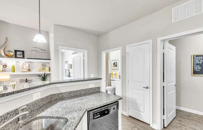Modern kitchen with a granite countertop and stainless steel appliances at Sterling Creek at Richmond Hill, Richmond Hill, 31324