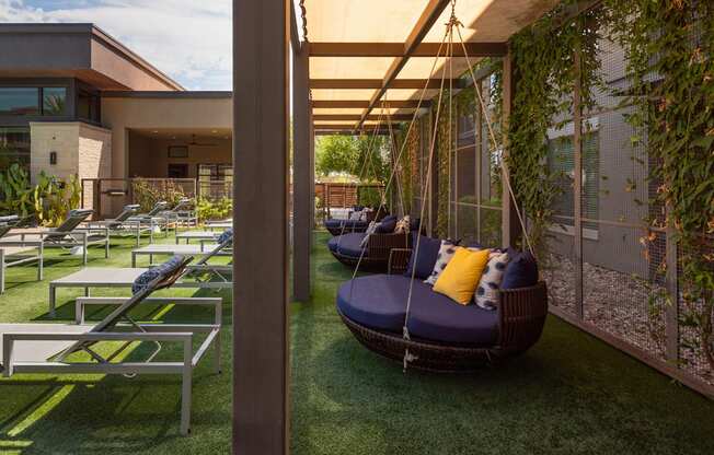 A patio with a swing and a table.