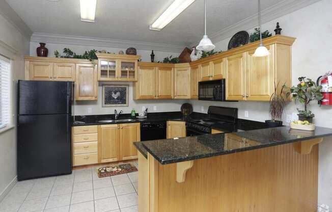 a kitchen with wooden cabinets and a black counter top