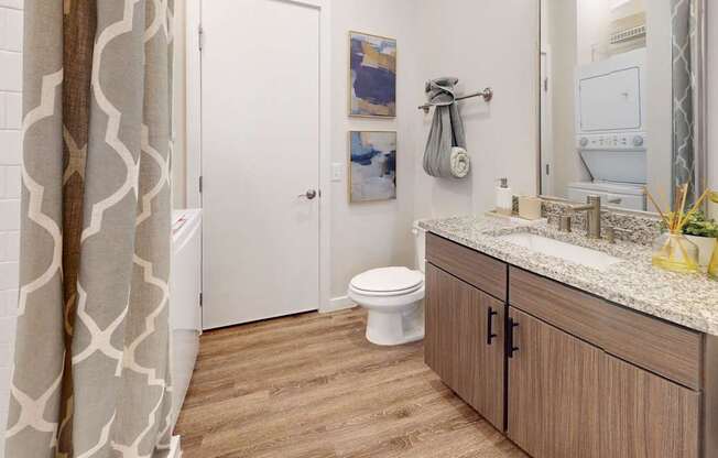 A bathroom with a toilet, sink, and shower curtain.