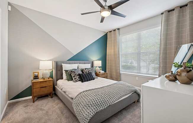 A bedroom with a bed, nightstand, and a ceiling fan.