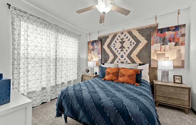A bedroom with a large bed and a ceiling fan.