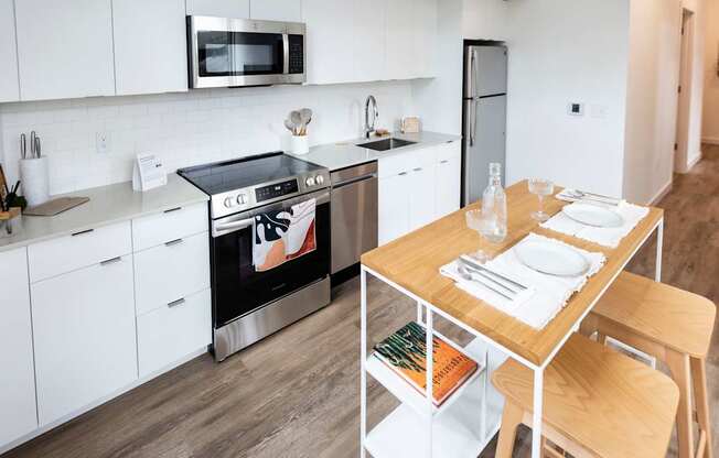 a kitchen with white cabinets and a wooden table