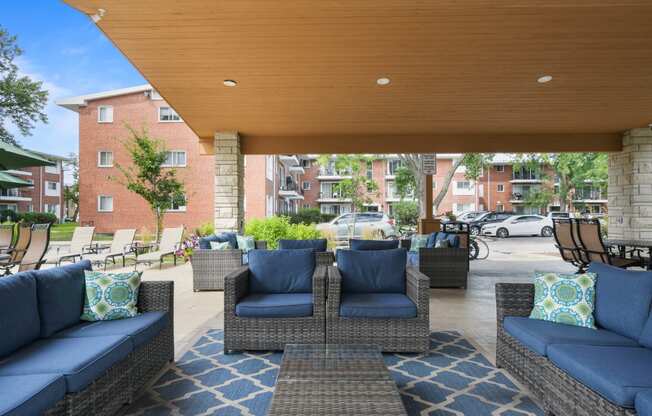 a patio with couches and chairs and a wooden ceiling