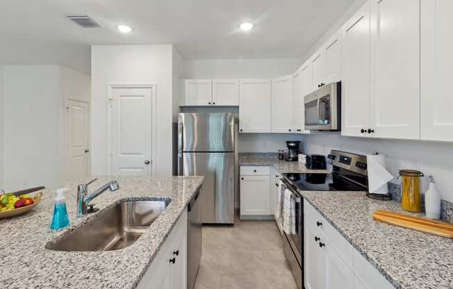 Boatman Hammock Townhomes in Lake Worth, FL photo of a large kitchen with granite counter tops and stainless steel appliances