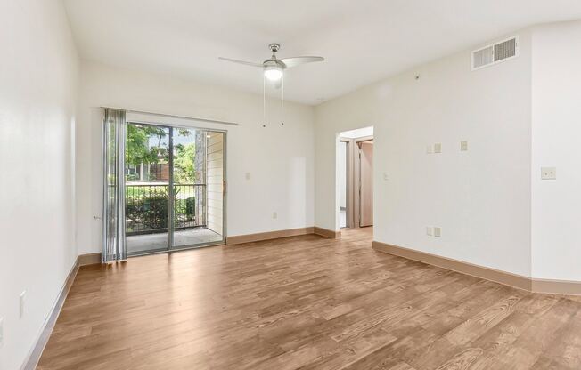 an empty living room with a sliding glass door to a patio at Lakeline East Apartments, Cedar Park