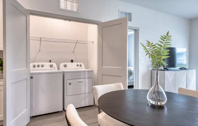 a kitchen and dining room with a table and chairs and a washer and dry