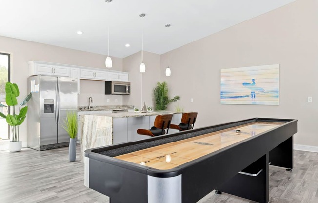 a games room with a foosball table and a kitchen in the background