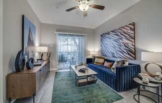 a living room with a blue couch and a ceiling fan