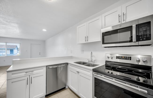 a kitchen with white cabinets and stainless steel appliances