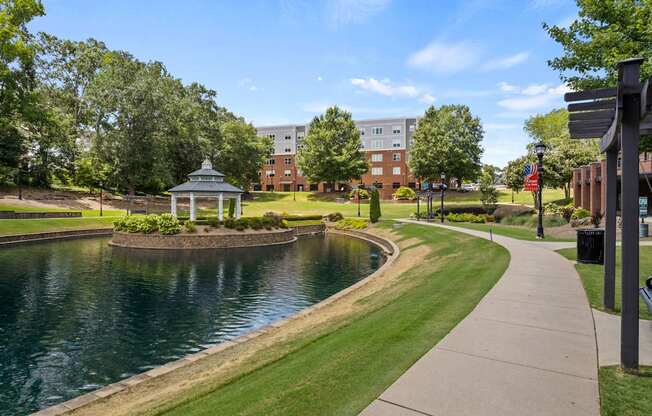 A serene park with a pond, gazebo, and walking path.