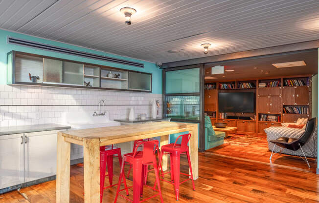 a kitchen with a wooden table and red chairs
