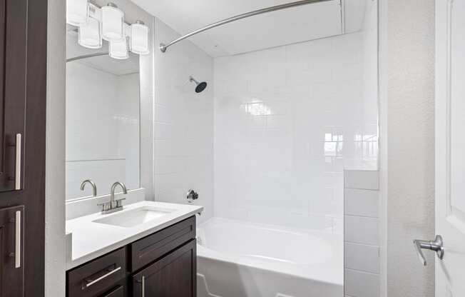 a bathroom with a tub and a sink and a mirror