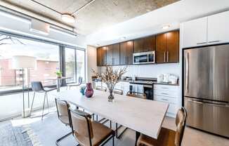 Kitchen and dining area with table and chairs.