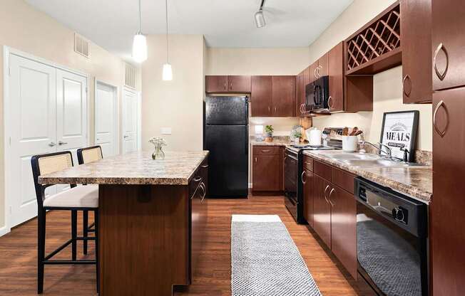 A kitchen with brown cabinets and a black refrigerator.
