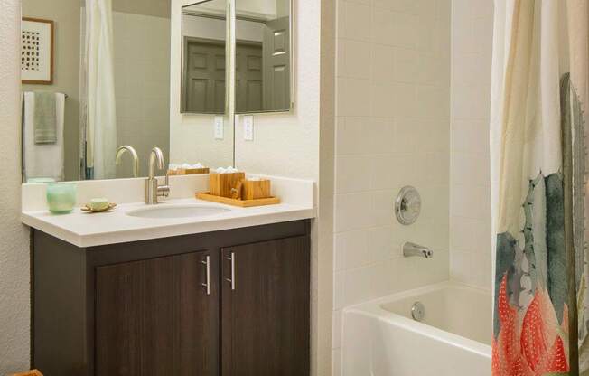 A bathroom with a white tub and a large mirror.