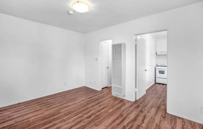 a living room with a hard wood floor and white walls