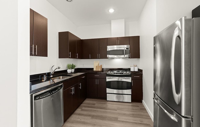 A modern kitchen with dark wood cabinets and stainless steel appliances.
