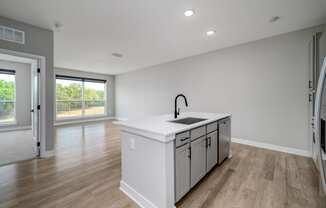 a large white kitchen with a large island in the middle