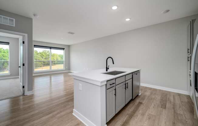 a large white kitchen with a large island in the middle