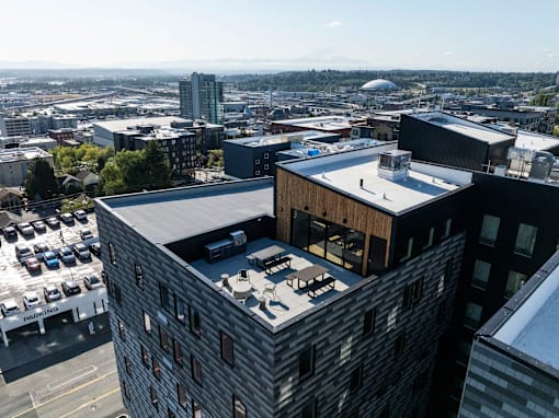 a building with a rooftop terrace and a city in the background at Moraine, Tacoma, Washington