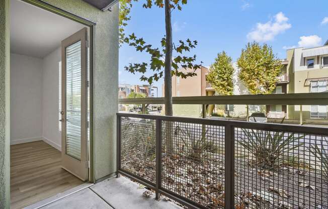 a balcony with a view of a yard and a tree