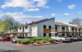 A parking lot with cars and a building with a red roof.