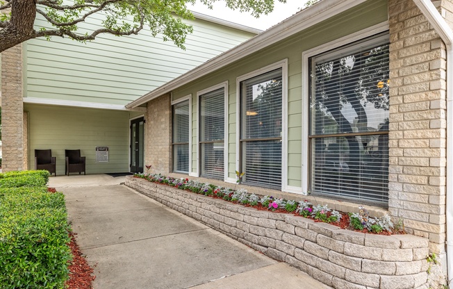 a walkway in front of a building with windows and a sidewalk