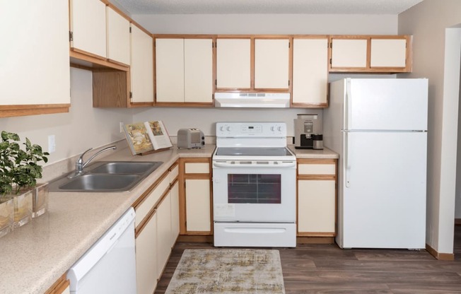 a kitchen with a white refrigerator freezer next to a white stove top oven