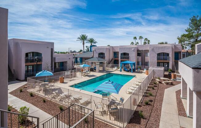 A pool surrounded by a fence and chairs.