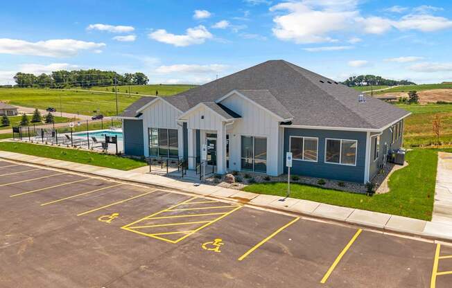 A parking lot with a building and a yellow handicap sign.