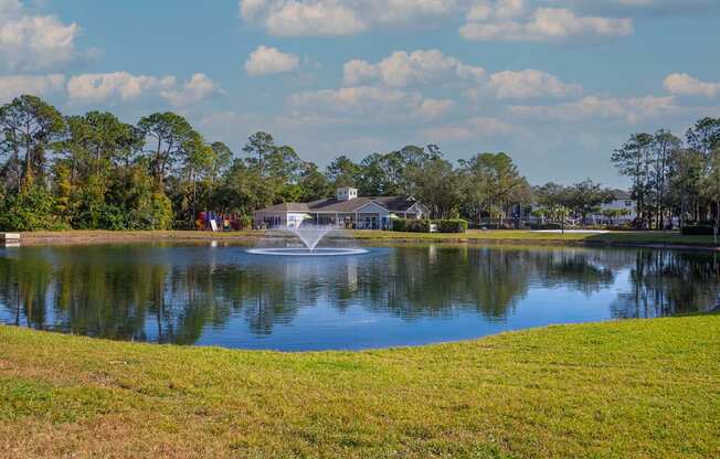 A fountain in the middle of a lake surrounded by trees.