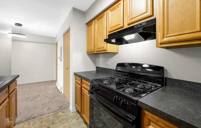 a kitchen with black appliances and wood cabinets